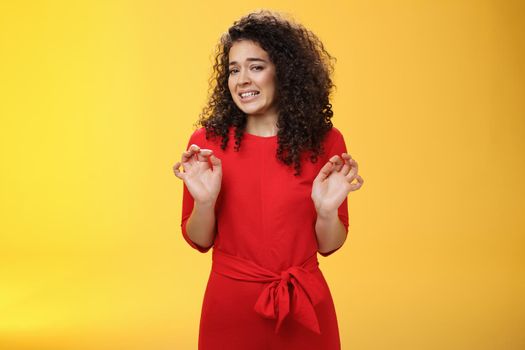 Girl hates washing dished grimacing from dislike and disgust wanting puke from aversion raising palms and stepping back frowning refusing displeasing offer over yellow background