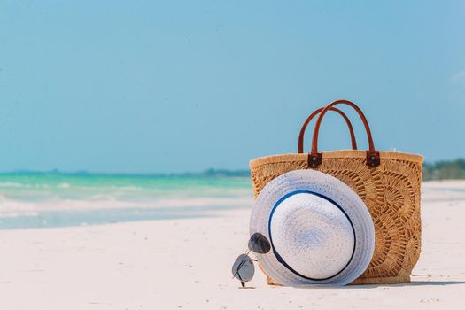Beach accessories - straw bag, hat and unglasses on the beach