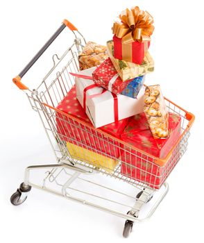 Shopping Cart is Full of Christmas Gift Boxes of Different Sizes, Colors and Shapes. Big Pile of Christmas Gifts in the Shopping Cart. Close-up. White Background