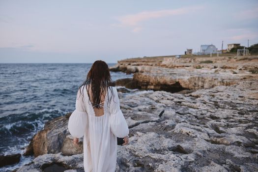 woman by the ocean rocks travel freedom. High quality photo