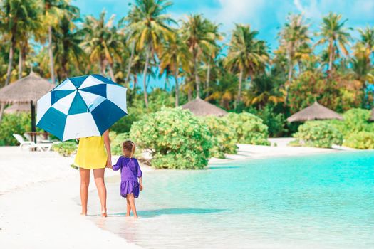 Family of mother and little girl on tropical beach