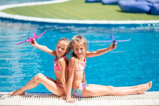 Beautiful little girls having fun near an outdoor pool