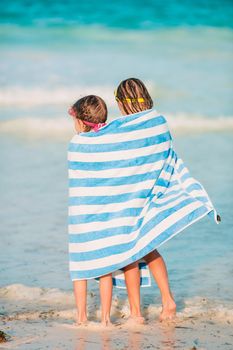 Adorable little girls wrapped in towel at tropical beach