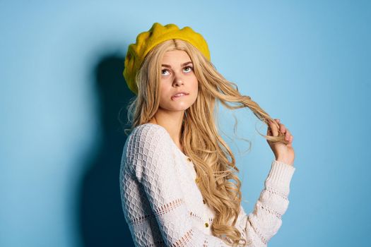 woman in yellow hat posing glamor blue background