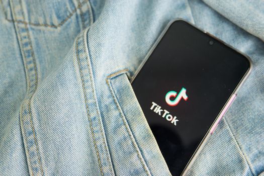 Tver, Russia-may 7, 2020, the tik tok logo on a smartphone screen sticks out of the pocket of a denim jacket. Tick-Tok icon. logo of the current app. Tiktok social network. Close up.