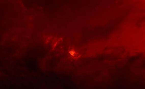Dark red dramatic clouds with sun glare