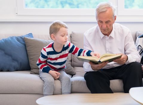 modern muslim grandfather with grandson reading Quran