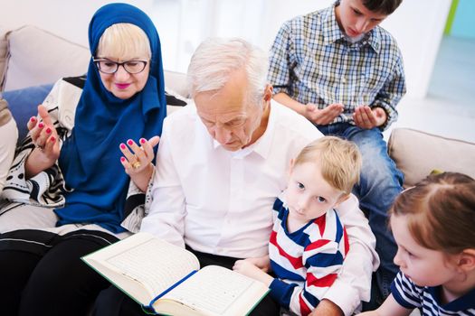 modern muslim grandparents with grandchildren reading Quran