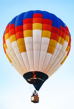 Multicolored air balloon in clear blue sky