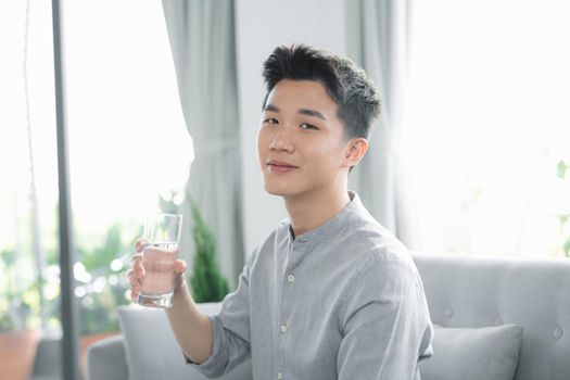 portrait of a young and masculine man drinking a water 