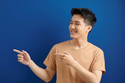 asian man with two finger point aside