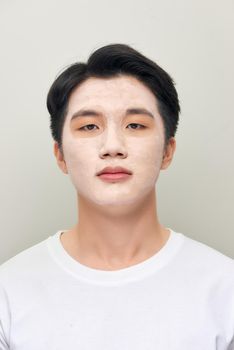 relaxing man with a mud mask on this face