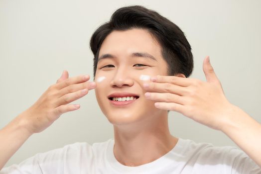 Young man with moisturizer on the face