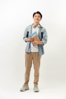 Smiling teenager with a schoolbag standing on wall background