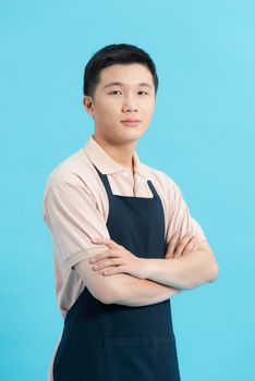 Handsome man in apron isolated on light blue background
