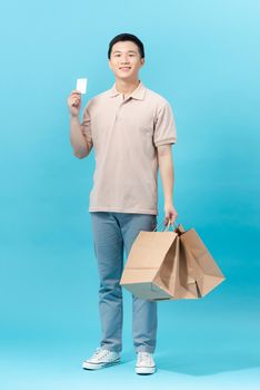 Young man showing his shopping bag and credit card