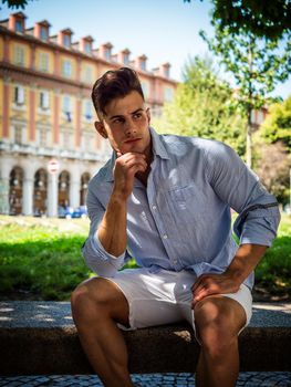 One handsome young man wearing shirt, in city setting