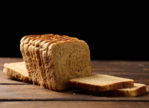 sliced wheat flour bread on a wooden board. Sandwich bread
