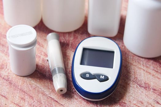 Close up of diabetic measurement tools and pills on color background