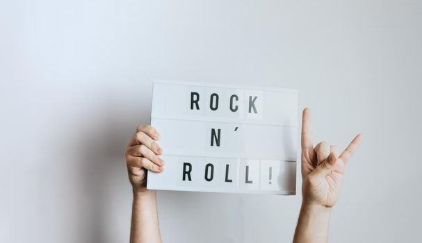 Hands holding a rock and roll sign while doing a heavy metal sign, white background, removable background music concept.