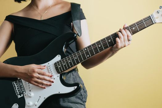 Conceptual studio image of a woman playing a electric guitar, yellow background, removable background, banner design, social network advertising, copy space
