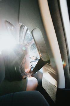 Beautiful Caucasian young hipster female posing during a car trip outside window. Van life lifestyle. Travel and happiness concept. Glasses during a sunset day