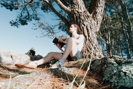 Young hippie male reading a book, wide angle shot, social network, summer vibes relaxed lifestyle