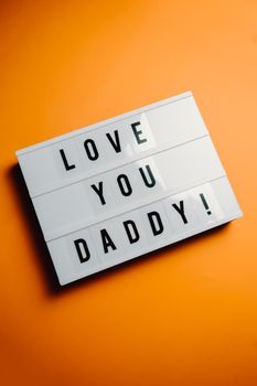 Dad day sign over a pastel pink background says love you daddy, love concept, minimal, copy space, style design