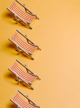 Summer beach chairs over a pastel yellow background with copy space, minimalism, summer and relax concept, networks