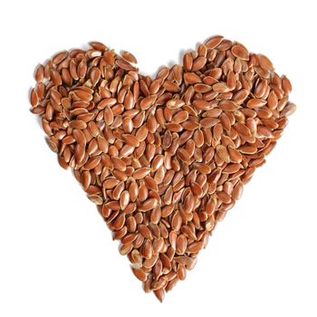 Heart made of flax seeds (Linum usitatissimum) view from above, isolated on white background. Food good for healthy heart concept.