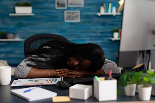 Tired worker falling asleep on desk while working