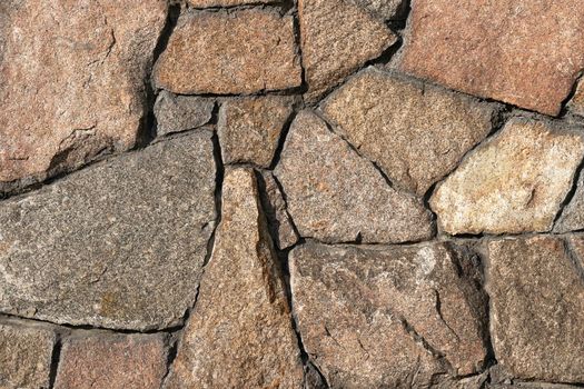 Stone wall of granite close-up, texture, background