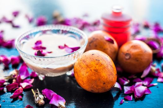 Face pack for cheeks on wooden surface consisting of sapodilla or chikoo well mixed with sandalwood using rose water in it.