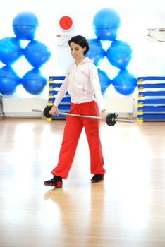 .a young woman weightlifting at gym 