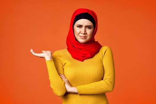 muslim woman in red hijab posing gesturing with hands isolated background