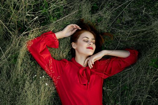 woman in red dress lies on the grass nature freedom summer