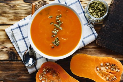 Creamy pumpkin soup on a wooden table