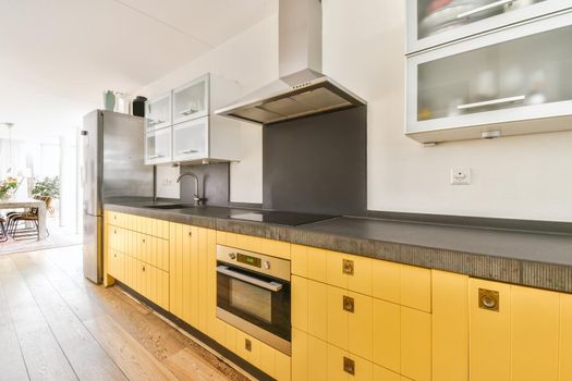 Pretty kitchen with yellow kitchen unit and hanging cabinets