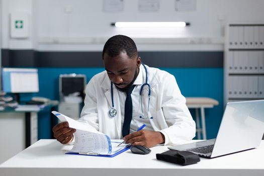 African american practitioner doctor checking medicine prescription paperwork