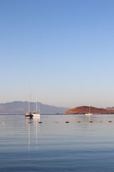 Beautiful sunrise on the Aegean Sea with islands, mountains and boats