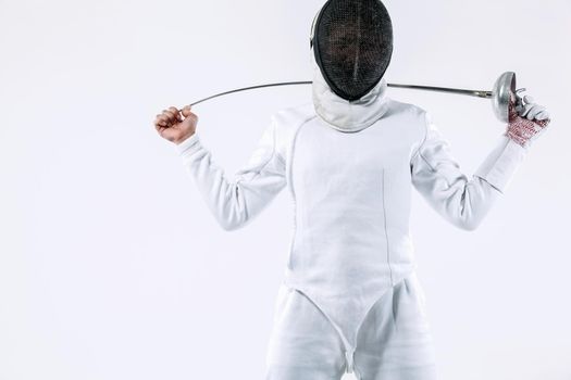 Fencer athlete wearing mask and white fencing costume and holding the sword, . Isolated on white background