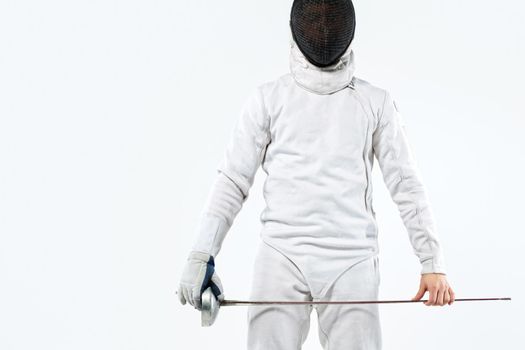 Fencer athlete wearing mask and white fencing costume and holding the sword, . Isolated on white background