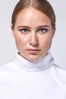 Closeup portrait of fencer athlete wearing fencing costume. Isolated on white background