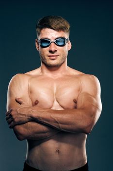 sports man with naked torso swimmer professional dark background