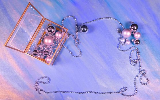 silver Christmas toys and garland on violet background, top view, flat lay, copy space