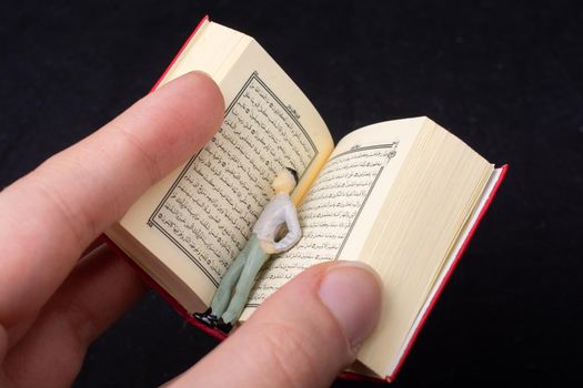 Islamic Holy Book Quran  with figurine in  hand  