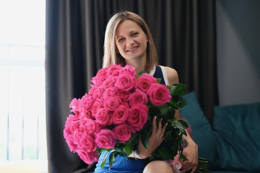 Beautiful young woman get bouquet of flowers on birthday or anniversary