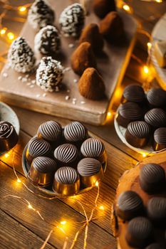 Assorted chocolates on wooden table with garland
