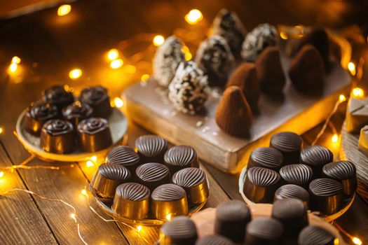 Assorted chocolates on wooden table with garland