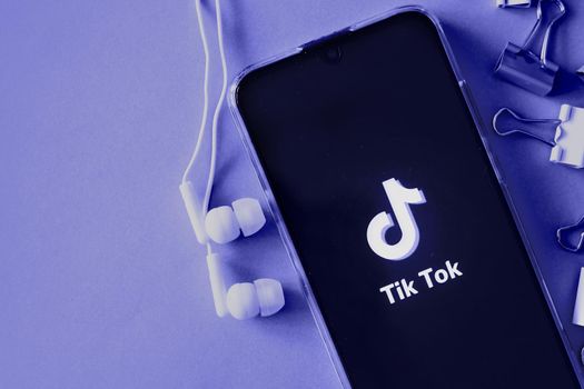 Tver, Russia-April 9, 2020, the tik tok logo on the smartphone screen with headphones. Tick-Tok icon. logo of the current app. Tiktok social network. Demonstrating the colors of 2022 - Very Peri